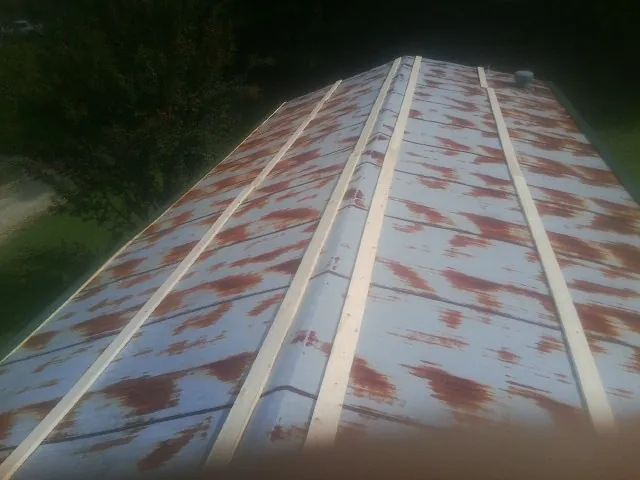 Rusted metal roof panels with new wood purlins before replacement — Storm Damage Roof Repair in Covesville by Roofing Brothers