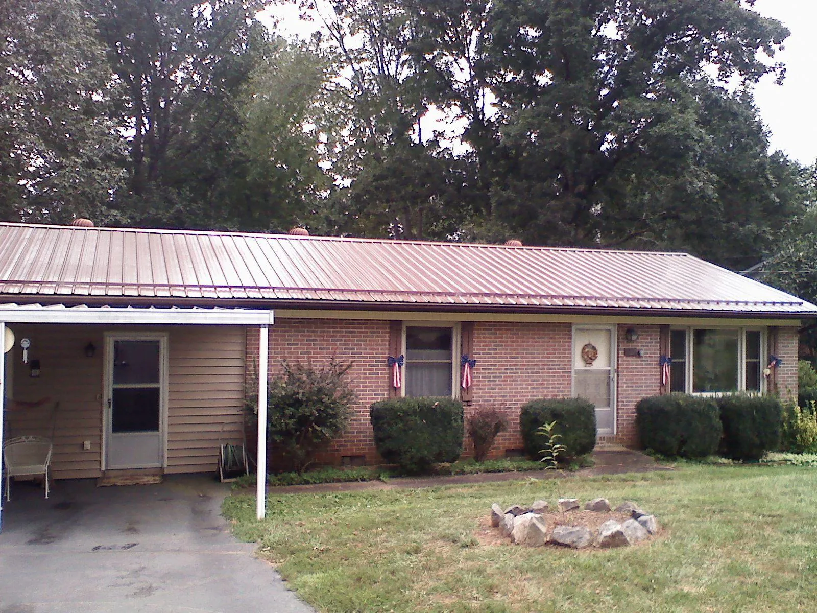 Bronze metal roof and carport on a brick ranch home — Roof Repair work by our crew in Covesville
