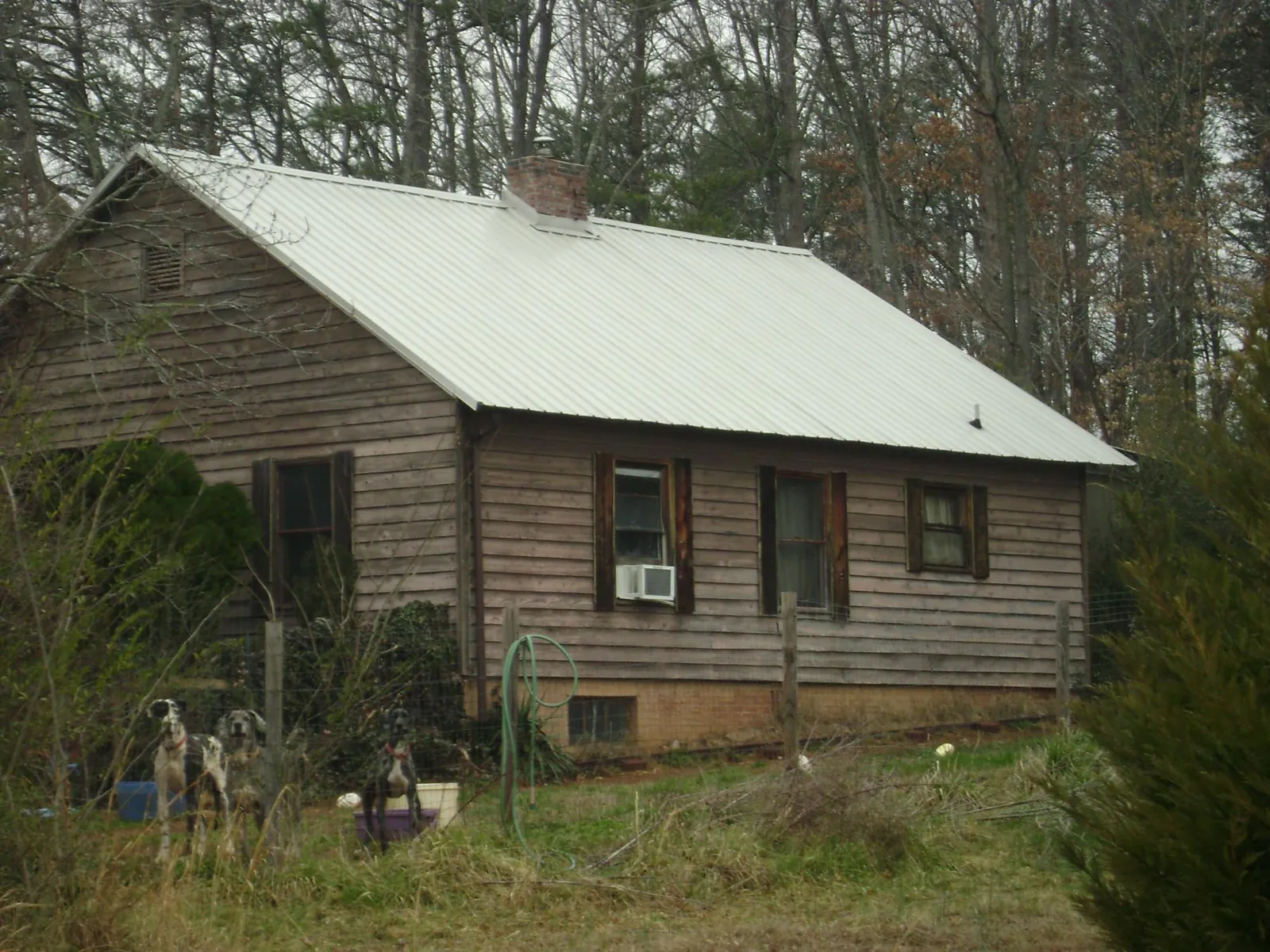 White metal roof on an old wood sided farmhouse, from a Metal Roof Installation job in Covesville
